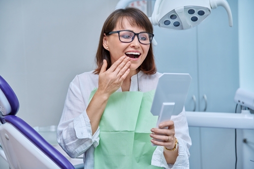 Middle-aged,Female,In,Dental,Office,Looking,In,Mirror